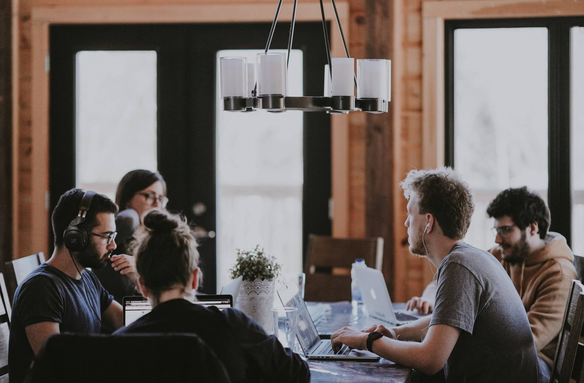 Five individuals at a table in an office space working