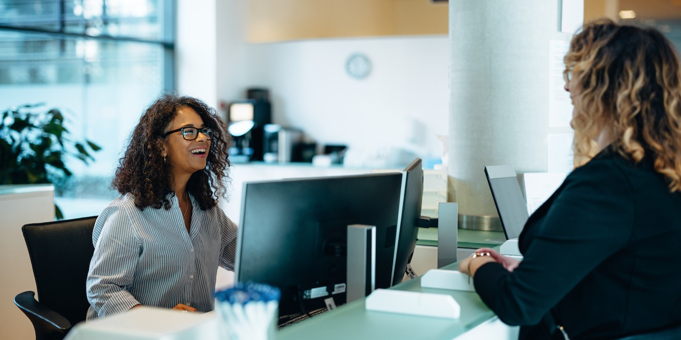 co-workers engaging in a delightful conversation while at their work desk