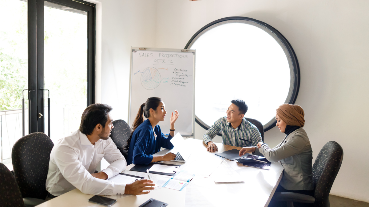 Sales people at a table discussing collaboration strategy